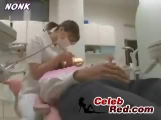 Japońskie dentist pielęgniarka daje na ręcznym do pacjent